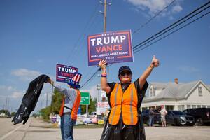 Héctor y Raquel Ramírez muestran su apoyo a Donald Trump frente a un colegio electoral en Cypress, Texas, el 5 de noviembre