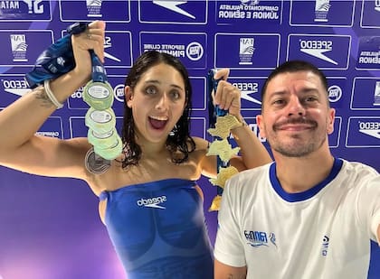 Hein, la coleccionista de medallas, con su entrenador, Sebastián Montero, pieza fundamental del engranaje de la nadadora nacida en Campana
