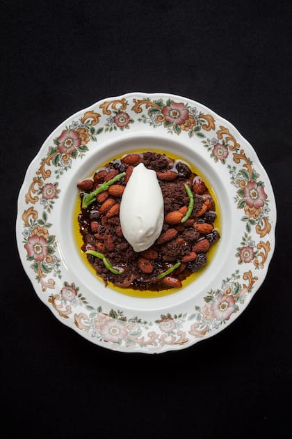 Helado de crema con crumble de chocolates, almendras enteras y salicornia, sobre aceite de oliva y más chocolate.