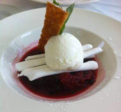 Helado de crema con salsa de frutos rojos y merengues