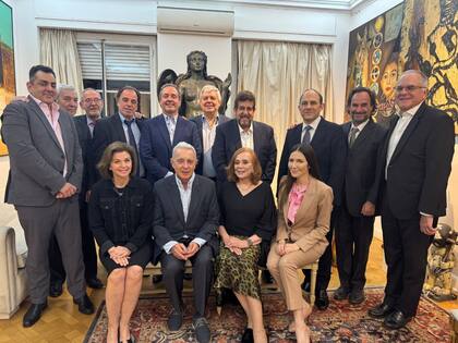 Helen Ferrer, sentada a la izquierda de Álvao Uribe, y Carlos Díaz Rosillo, de pie detrás del expresidente, en el centro de la imagen que dejó la cena de María Cristina Guzmán