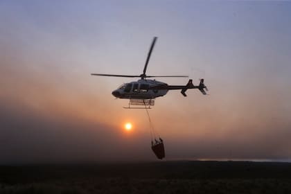 Helicópteros arrojan agua para apagar los incendios