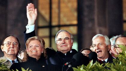 Helmut Kohl (centro) saluda el 3 de octubre de 1990 desde las escalinatas del Reichstag en Berlín