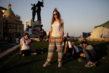 Hiba Ghosn, de 36 años, que trabaja en la industria de la moda junto a sus amigos sentados al sol de la tarde en la plaza de los Mártires, mientras la gente se reúne para una manifestación durante las protestas contra el gobierno en curso en Beirut, Líbano, el 17 de noviembre de 2019.