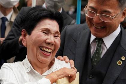 Hideko Hakamada comparte una sonrisa con un abogado de su hermano fuera de la corte