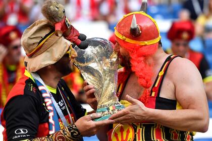 Hinchas de Belgica besan una replica de la copa Mundial