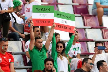 Hinchas iraníes levantan carteles a favor de los derechos de las mujeres en la previa del partido contra Inglaterra en el Estadio Internacional Jalifa.