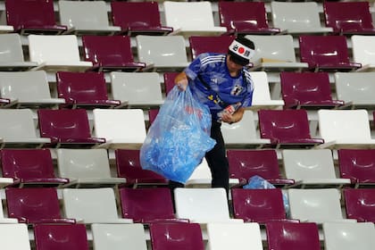 Hinchas japoneses recolectan la basura después del partido entra Alemania y Japón