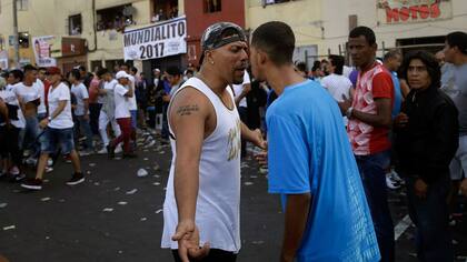 Hinchas rivales discuten durante campeonato de fútbol callejero Mundialito de El Porvenir en Lima, Perú.