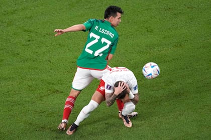 Hirving Lozano disputa el balón con Nicola Zalewski en el último México-Polonia