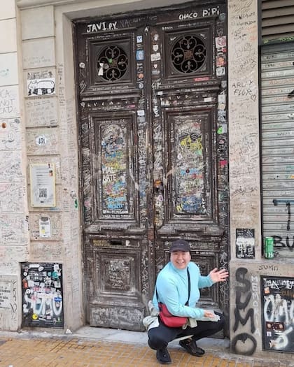 Hiyori Kon en San Telmo, en la puerta de la casa donde murió el músico Luca Prodan, junto a un graffiti del grupo "Sumo"