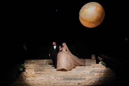 Como en una imagen de las Mil y una noches, los novios descienden por la escalinata mientras un espectáculo de fuegos artificiales ilumina la noche libanesa