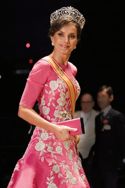 Letizia impactó con un traje hecho a medida de Carolina Herrera. Completó su look con una petaca de la misma firma (modelo Scala Insignia, cuesta 450 euros) y la tiara Flor de Lis, una de las joyas de pasar más importantes de la corona española. La Reina usó esta tiara por primera vez en 2017, duran