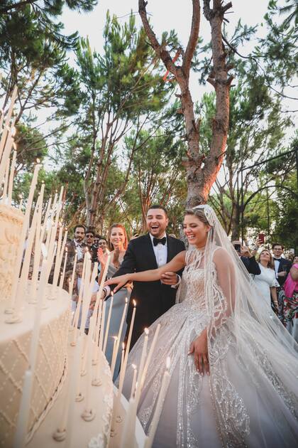 Los novios cortan la torta de boda de nueve pisos y un metro y medio de altura adornada con 365 velas, una por cada día del año.