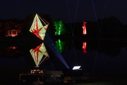 Hologramas reflejados sobre el agua y esculturas iluminadas