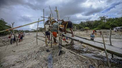 Hombres lavan sedimentos con oro en la orilla de un rio en El Callao, estado Bolívar, en el sureste de Venezuela