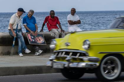 Hombres mayores se reúnen en el malecón de La Habana. (Foto AP/Ramón Espinosa, Archivo)