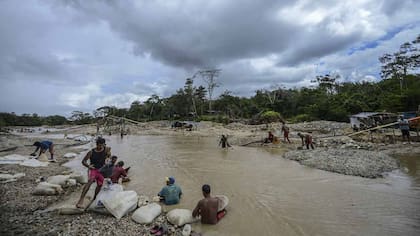 Hombres trabajan en la mina de oro de Nacupay, a orillas de un rio en El Callao, estado Bolívar, en el sureste de Venezuela