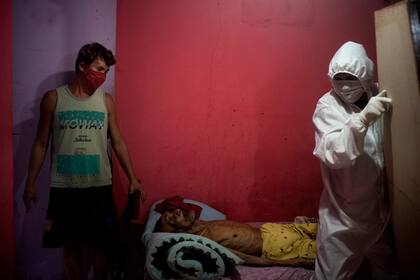 Hombres vestidos de pies a cabeza con trajes de protección llevaron un ataúd vacío hasta la pequeña vivienda blanca y azul donde Edgar Silva había pasado dos febriles días intentando respirar