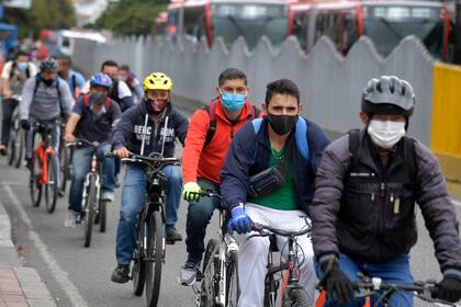 Hombres viajan por una ciclovía en Bogotá el 19 de mayo de 2020, después de que el alcalde de la ciudad las expandió temporalmente durante la pandemia de coronavirus