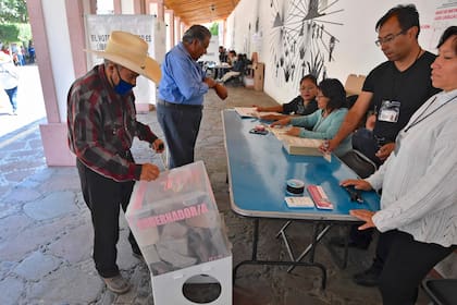 Hombres votan en un colegio electoral en Tepetlaoxtoc de Hidalgo, México, el 4 de junio de 2023, durante las elecciones a gobernador en el Estado de México.