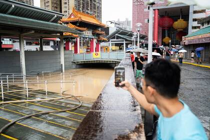 Un toma una fotografía de una zona inundada en el centro de Hong Kong