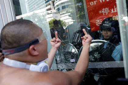 Alrededor de cien personas usaron un carrito de carga para estrellarlo contra un ventanal de vidrio del edificio