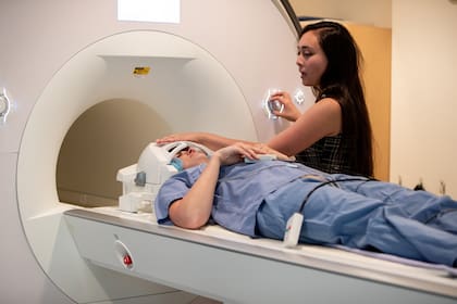 Hope Kean, estudiante de posgrado en el MIT, prepara a Helen Santoro para una resonancia magnética cerebral