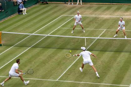 En el Court 18 de Wimbledon, Horacio Zeballos voleando mientras lo cubre Marcel Granollers; el argentino y el español avanzaron a las semifinales.