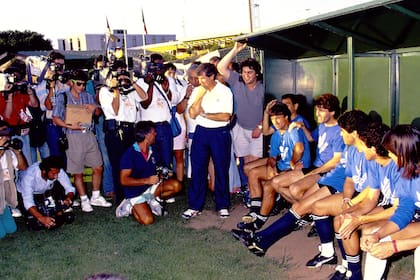 Horas antes del partido, los jugadores argentinos atienden a la prensa; en el fondo se puede apreciar dos banderas y un mástil vacío por el incidente en Trigoria