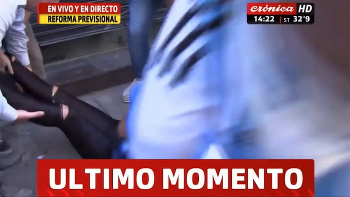 Una manifestante desmayada recibe la asistencia de sus compañeros