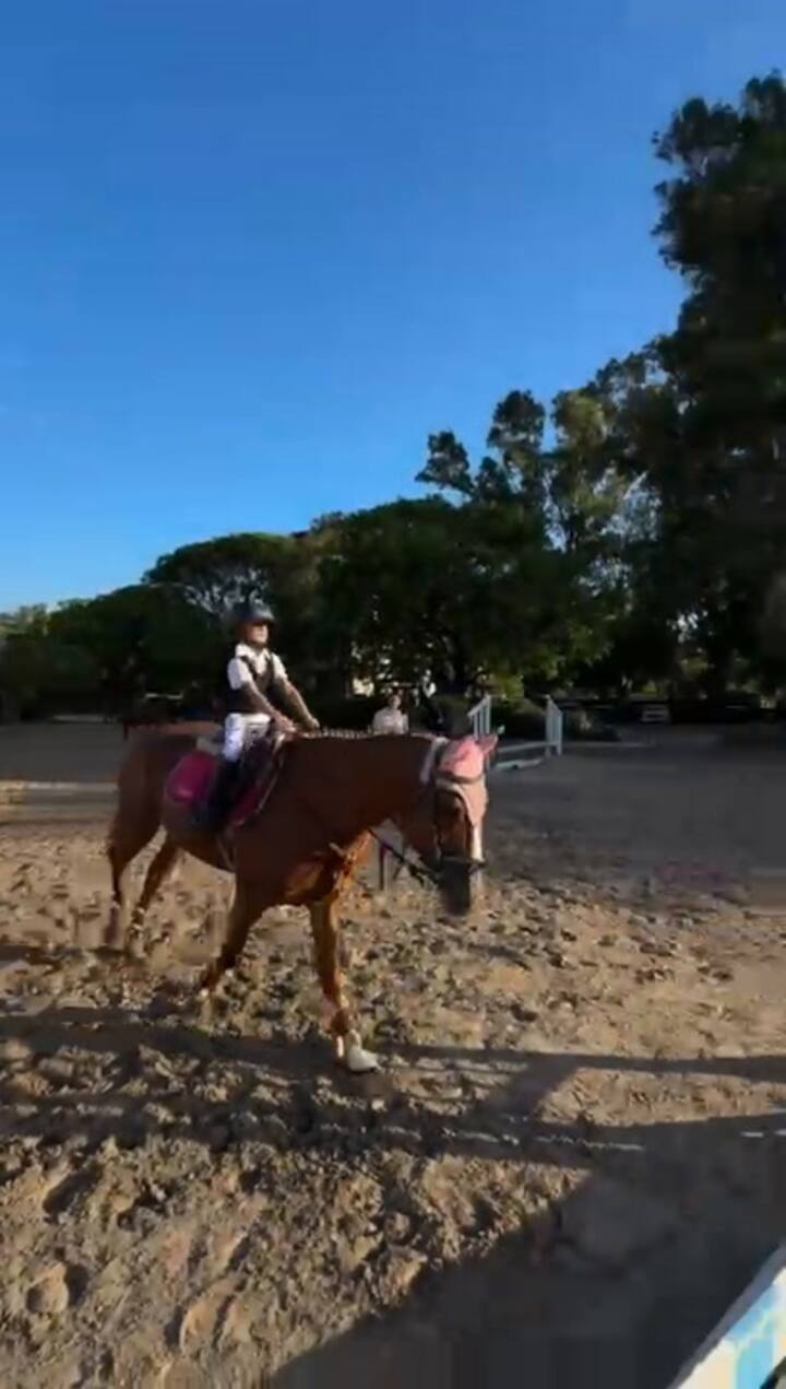 Siguiendo las indicaciones de su entrenadora, India salta con su yegua
