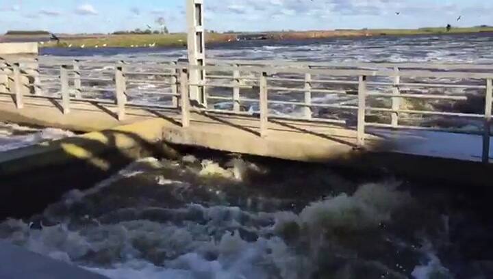 El agua pasa por encima de las compuertas de la laguna Mar Chiquita, en Junín