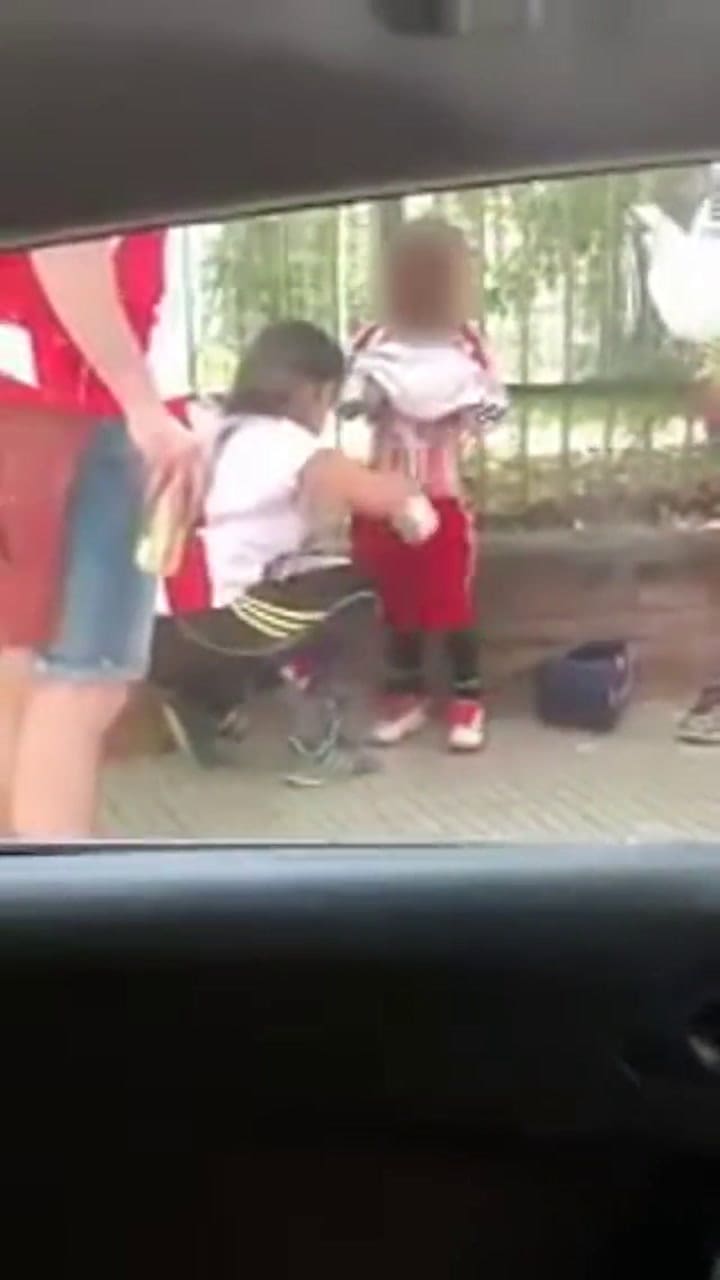 Una hincha de River le coloca bengalas a un menor