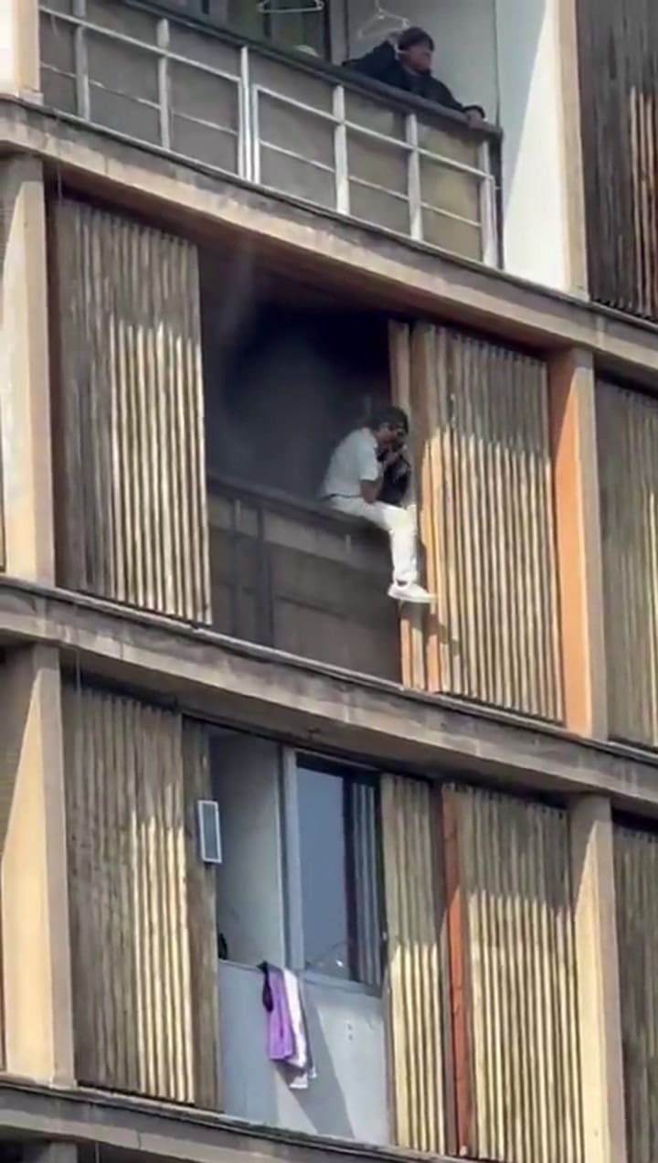 Vecinos intentan escapar del fuego desde las ventanas de un edificio en llamas en el centro de Santiago