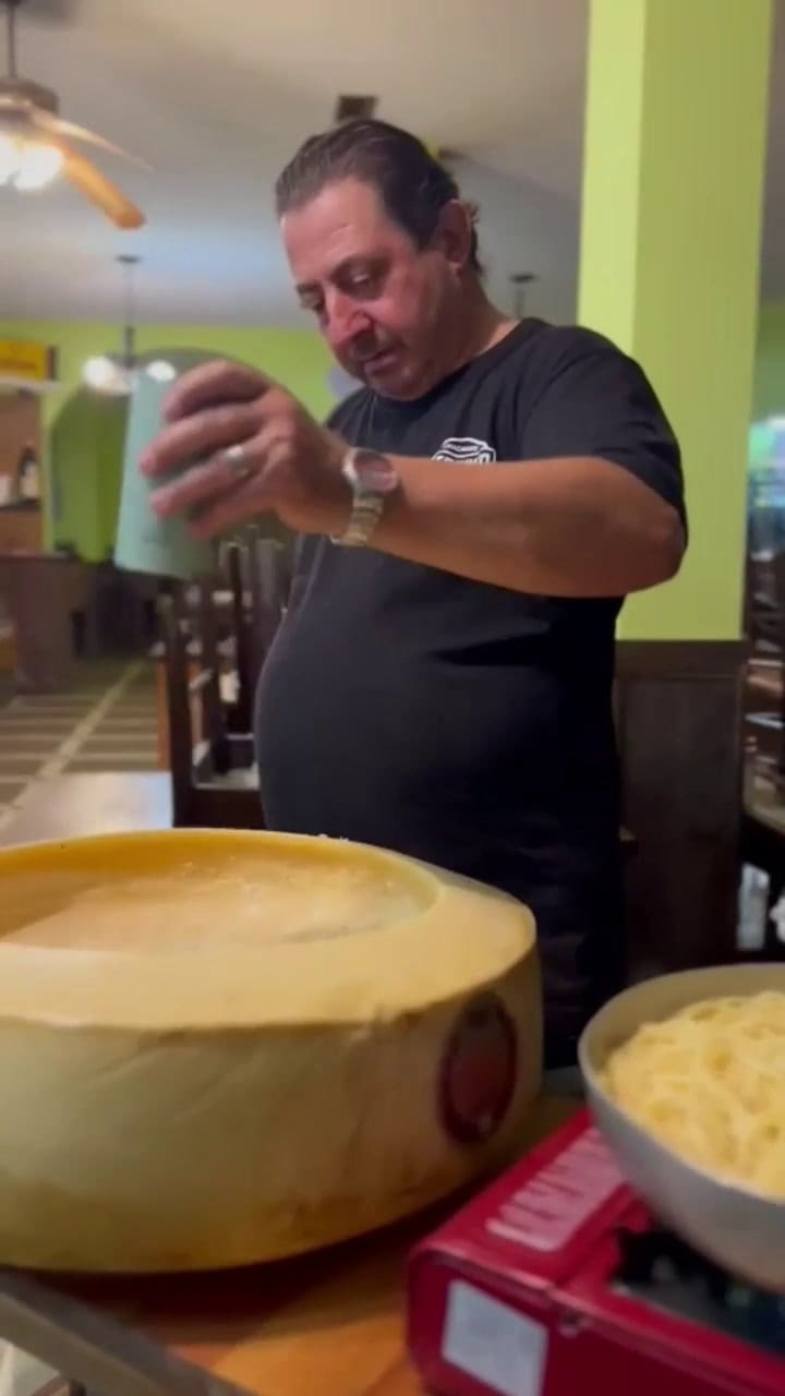 Esteban prepara uno de los platos estrella en la horma de queso gigante