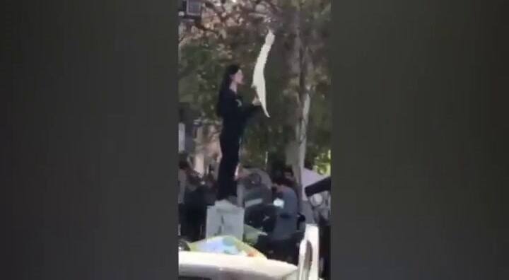 Una mujer que flamea su velo, el símbolo de la protestas en Irán