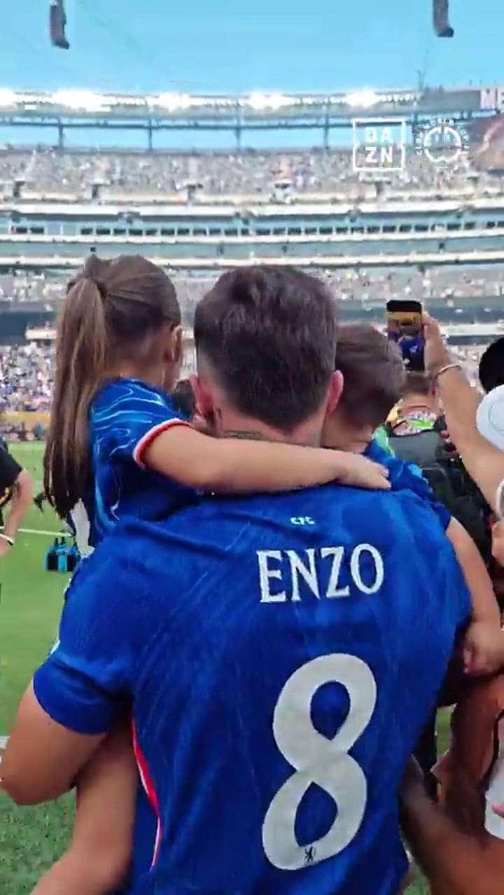 Valentina Cervantes desde la tribuna le alcanza sus hijos a Enzo Fernández