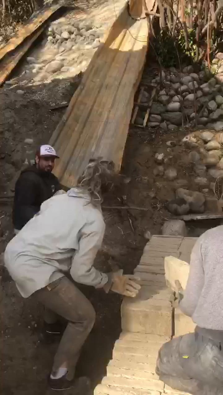 Los vecinos Carolina y Polo descargan ladrillos para su taller