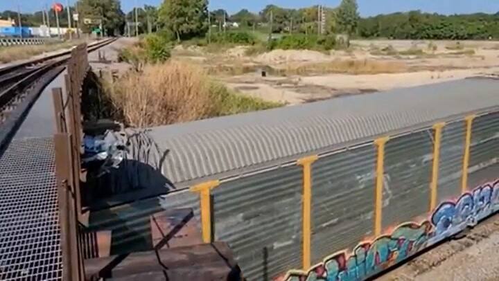 El increíble impacto de un tren cargado de autos contra un puente demasiado bajo