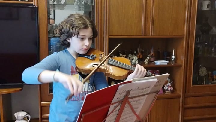 Marcos practicando el violín en su casa