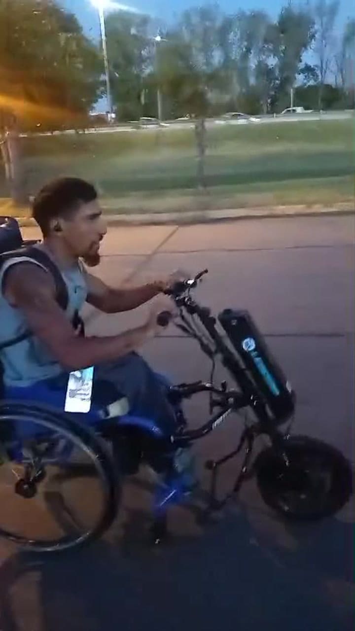 Leo usando el accesorio que convierte su silla de ruedas en una handbike motorizadarón