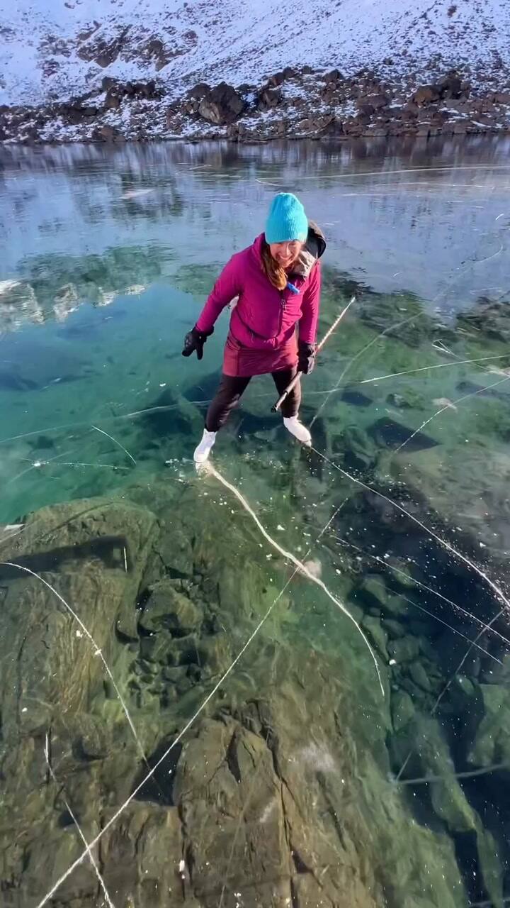 Una pareja patina sobre un lago transparente en Alaska