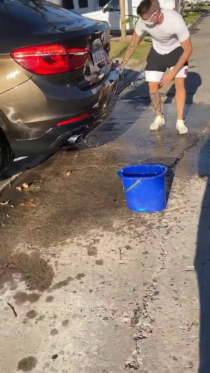 Ricardo Centurión lavando su BMW en la vereda