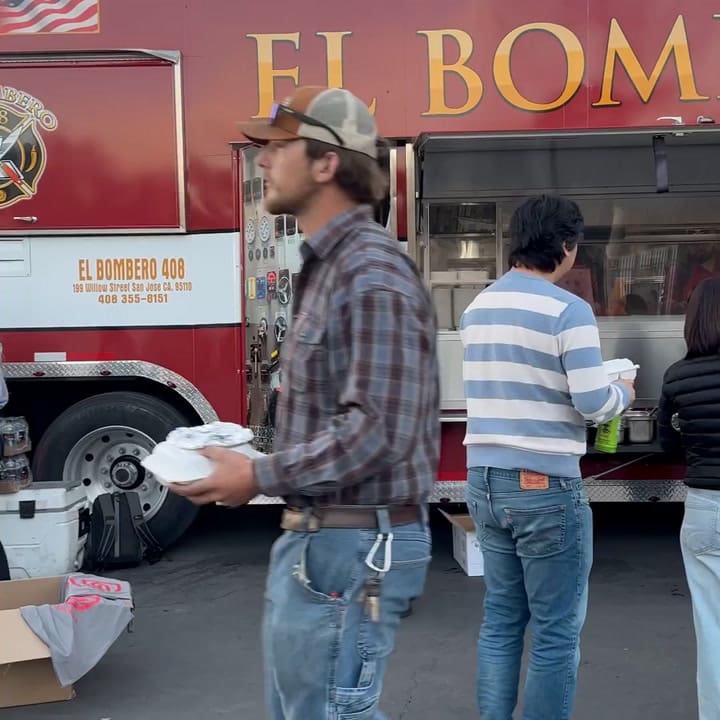 Bomberos y voluntarios hacen fila para comer tras horas de trabajo en los incendios