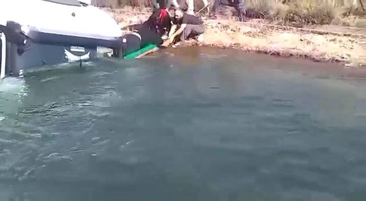 El momento en el que vecinos sacan del agua al chofer