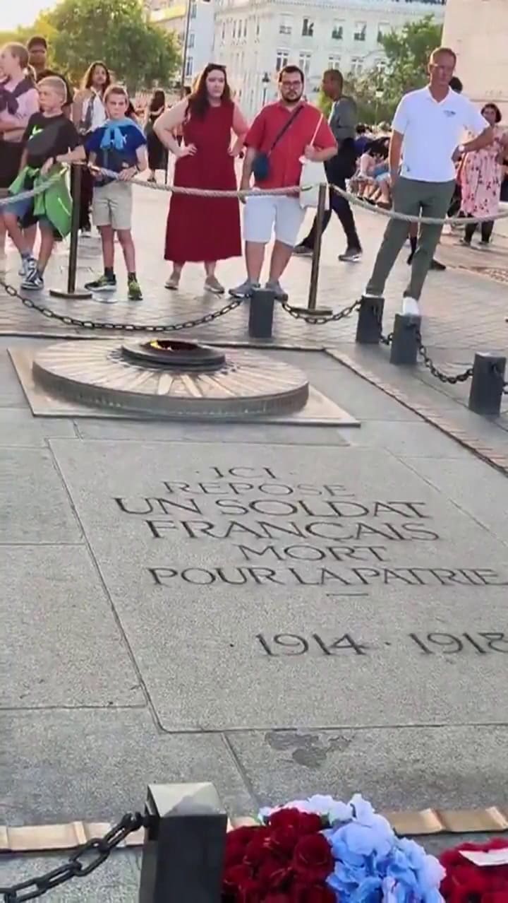 Un hombre marroquí enciende un cigarrillo en la llama eterna de París