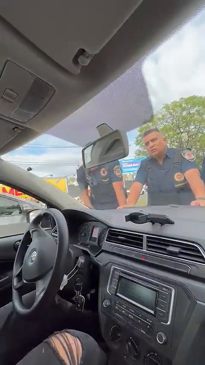 El gesto de desesperación de dos policías mientras son arrastrados en el capot de un automóvil