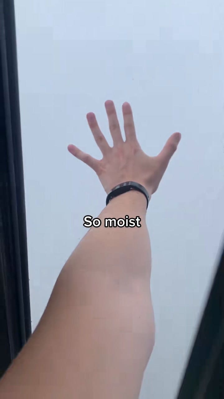 El residente abre la ventana, extiende la mano para tocar las nubes y muestra cómo la niebla cubre por completo la vista