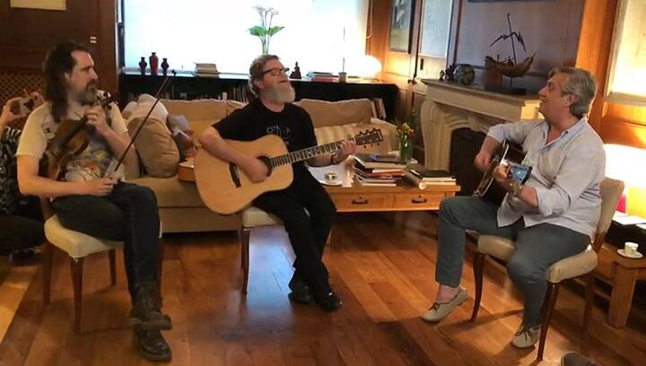 Alberto Fernandez tocando la guitarra con Gustavo Santaolalla